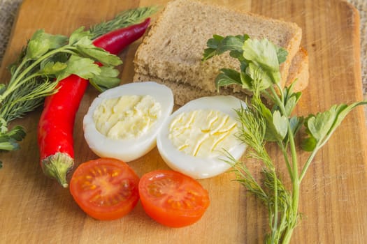 boiled egg, tomato, pepper on cutting board