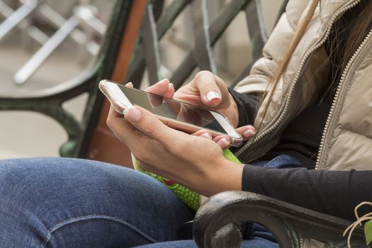 girl with French manicure holding a mobile phone