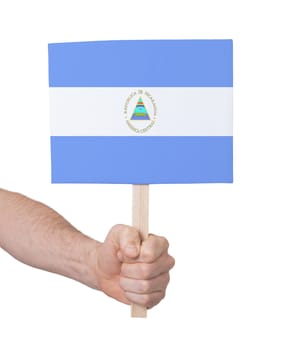 Hand holding small card, isolated on white - Flag of Nicaragua