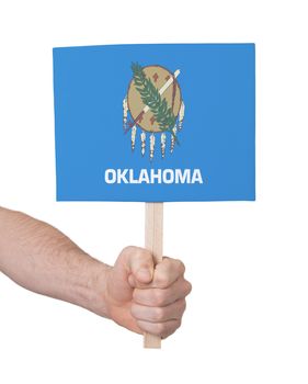 Hand holding small card, isolated on white - Flag of Oklahoma