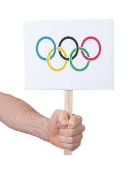 Hand holding small card, isolated on white - Flag of the Olympic games