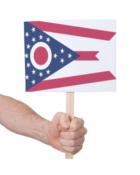 Hand holding small card, isolated on white - Flag of Ohio