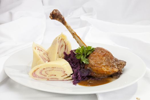 Baked duck leg with red cabbage and Ham filled  potato dumplings