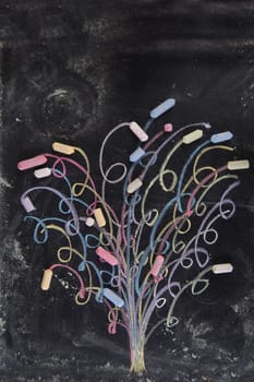 Representation drawn with chalk on the blackboard of a colorful tree