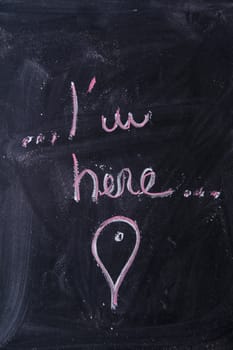 Graphic representation with chalk on the blackboard of the sentence ... I am here ...