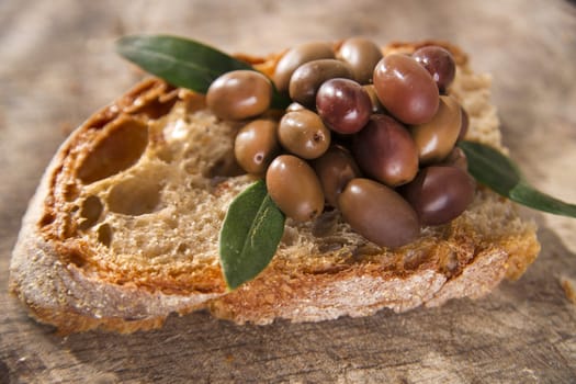 Snack of slice of bread with olives in brine