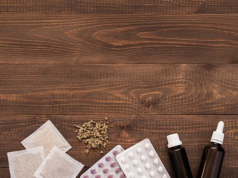 tablets, drops and herbals on a dark wooden background with copy space. Flat lay or top view