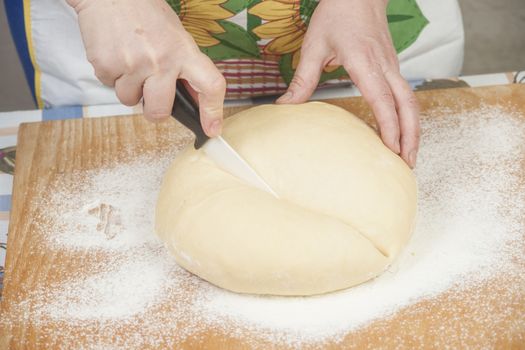 Ball of pizza dough with flour on the wooden table