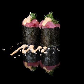 Vertical roll with tuna and seaweed on black background