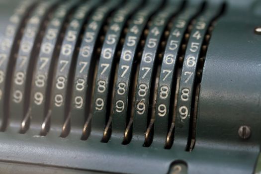Close up detailed view of historical old calculator with small iron buttons.