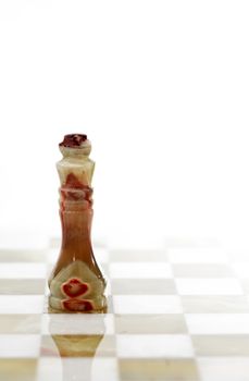 Chess King made from Onyx on board against white background