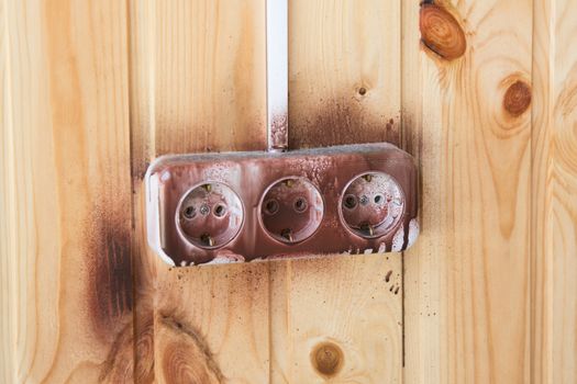 Dirty and splashed liquid triple socket on the wall of wood