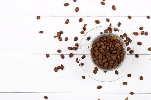 Coffee beans in the cup on a wooden background