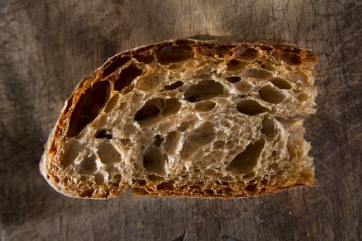 Slice of whole wheat bread on sourdough-border cooked in a wood oven