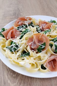 Pasta with spinach, ham and parmesan cheese for milk sauce