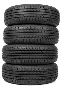 Stack of four new black tyres. Isolated on white background