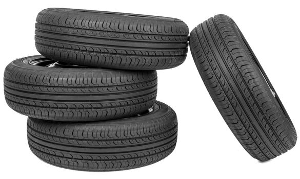 Stack of four wheel new black tyres, isolated on white background