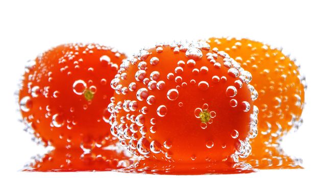 Cherry Tomatoes with gas bubbles. Isolated on a white background. 
Soft focus view.