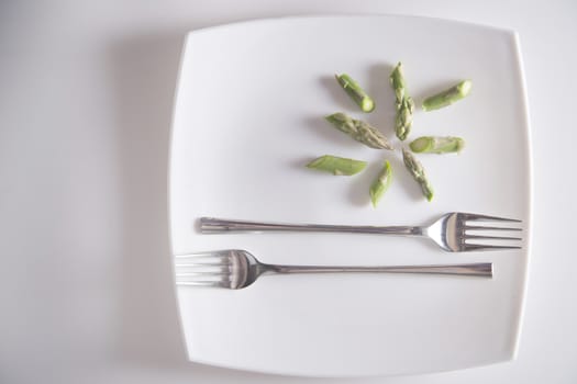 Presentation of raw asparagus spears on a white background