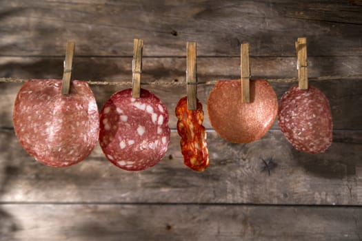 Presentation of slices of salami hanging by a thread