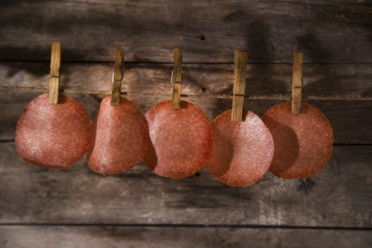 Presentation of slices of salami hanging by a thread