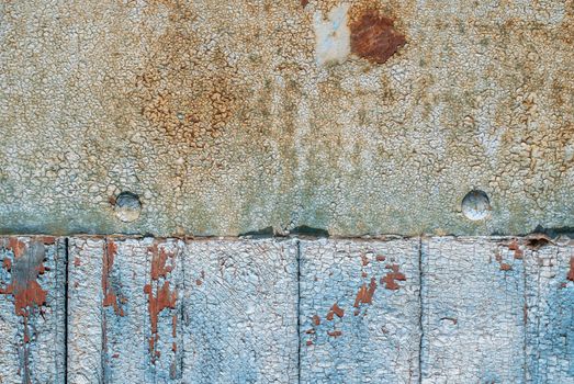 the door of planks covered with sheets of rusty metal, chipped old paint, which has long been under the influence of various climatic conditions