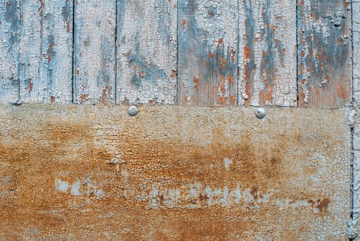 the door of planks covered with sheets of rusty metal, chipped old paint, which has long been under the influence of various climatic conditions