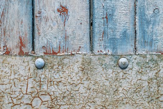 the door of planks covered with sheets of rusty metal, chipped old paint, which has long been under the influence of various climatic conditions
