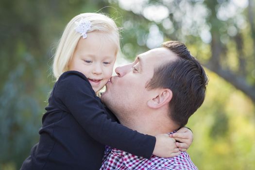 Loving Father Kissing Adorable Little Girl Outdoors.