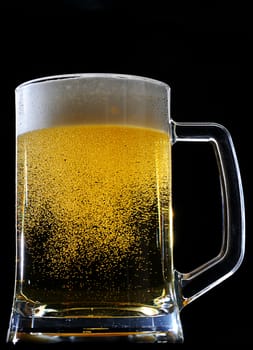 Fresh beer in glass with foam in sparkles