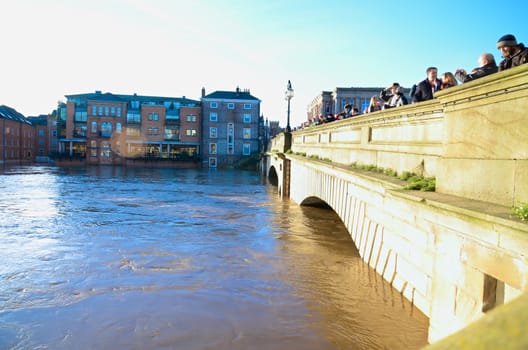 Flooded York by river Ouse in Yorkshire UK at december 2015. People observe  river from bridge




