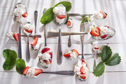 Presentation of the strawberries with cream spoons on various 