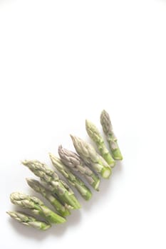 Presentation of raw asparagus spears on a white background