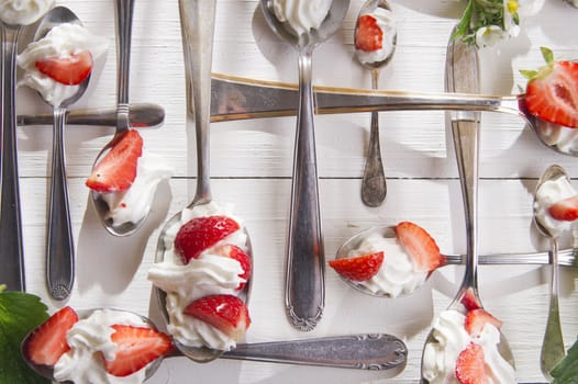 Presentation of the strawberries with cream spoons on various 