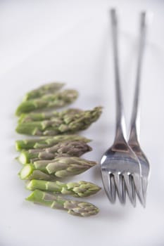 Presentation of raw asparagus spears on a white background