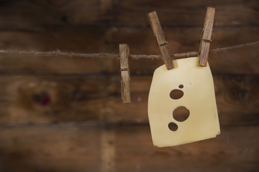 Presentation of slices of Swiss cheese Emmentaler hanging by a thread