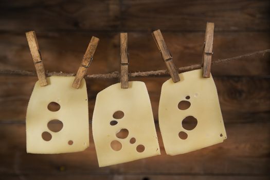 Presentation of slices of Swiss cheese Emmentaler hanging by a thread