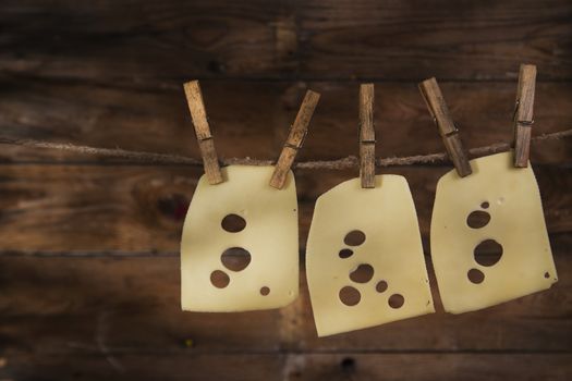 Presentation of slices of Swiss cheese Emmentaler hanging by a thread