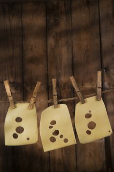 Presentation of slices of Swiss cheese Emmentaler hanging by a thread