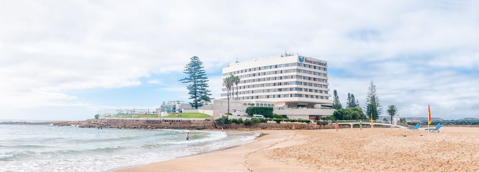 PLETTENBERG BAY, SOUTH AFRICA - MARCH 3, 2016: Unidentified tourists on a beach with a well known landmark, a hotel, in the back on Beacon Island