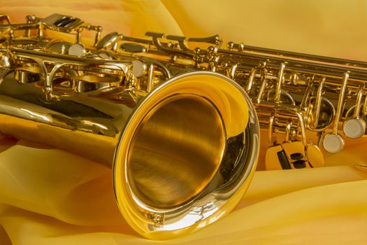 beautiful golden saxophone on delicate Yellow silk background