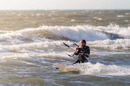 Kitesurfer in action on a beautiful background of spray during the sunset.