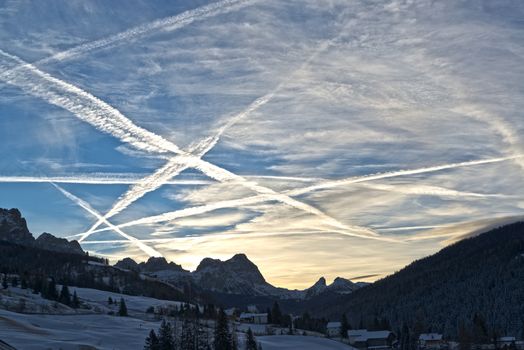 beautiful winter sunrise in the italian mountains and cloudy sky with aircraft contrails, Dolomiti