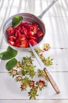 Preparing a fruit salad, strawberries into small pieces. 