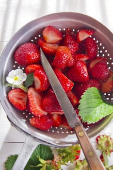 Preparing a fruit salad, strawberries into small pieces. 