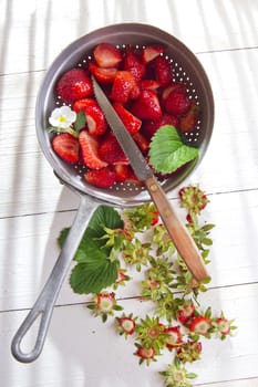 Preparing a fruit salad, strawberries into small pieces. 