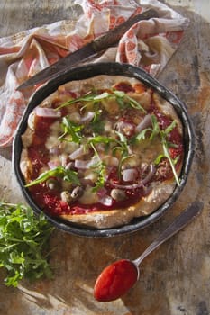 Pizza base with whole wheat flour with arugula and onion 

