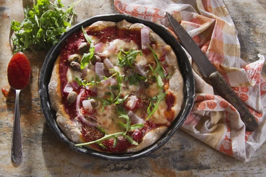 Pizza base with whole wheat flour with arugula and onion 

