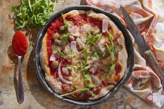 Pizza base with whole wheat flour with arugula and onion 

