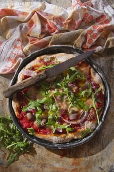 Pizza base with whole wheat flour with arugula and onion 

